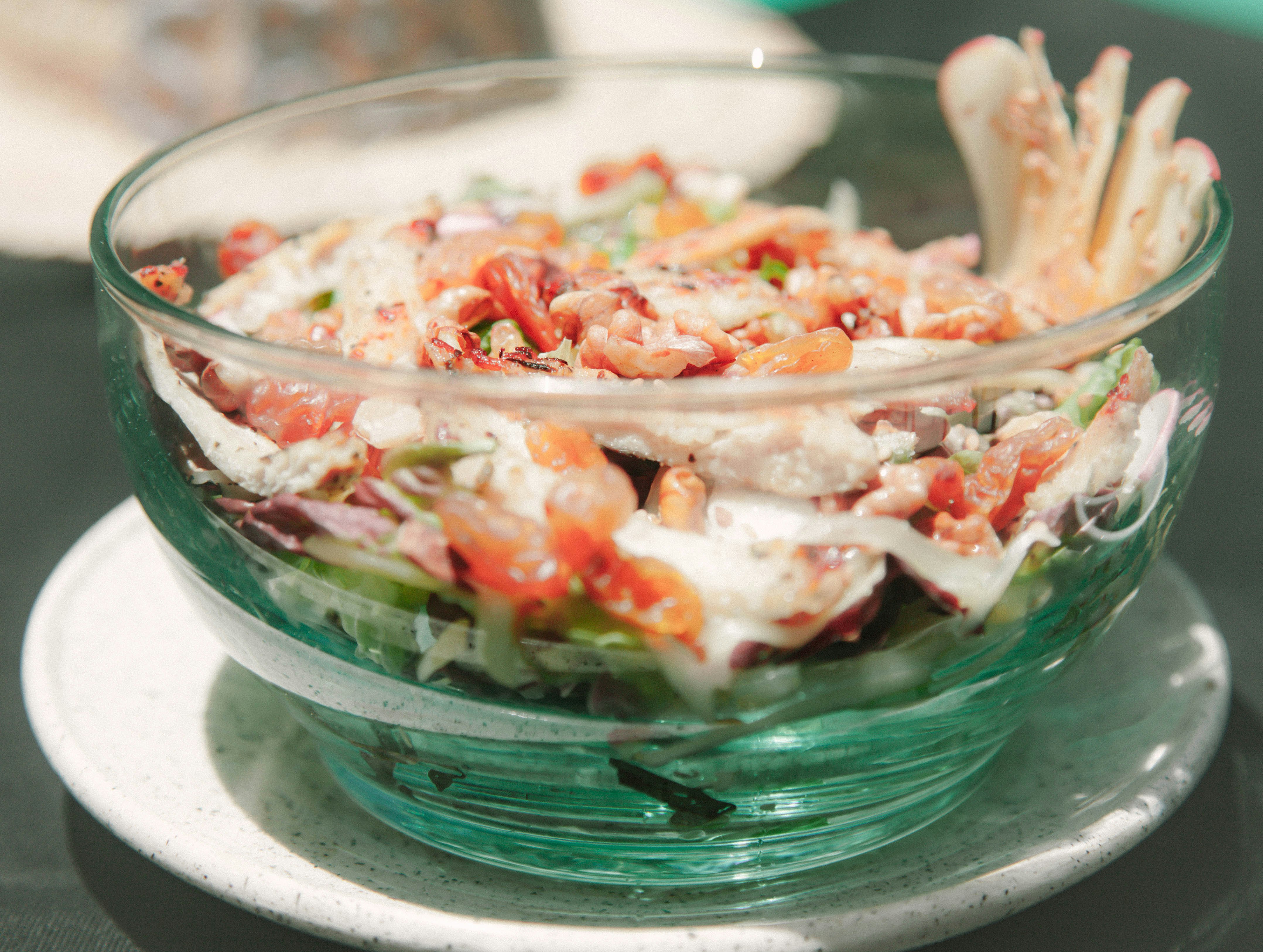 red and white sliced vegetables in green glass bowl